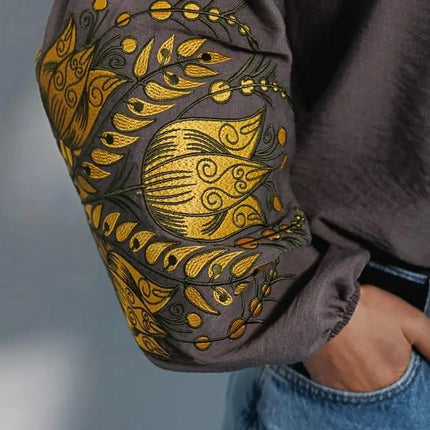 Women's embroidered blouse in graphite color with smooth floral patterns on the sleeves